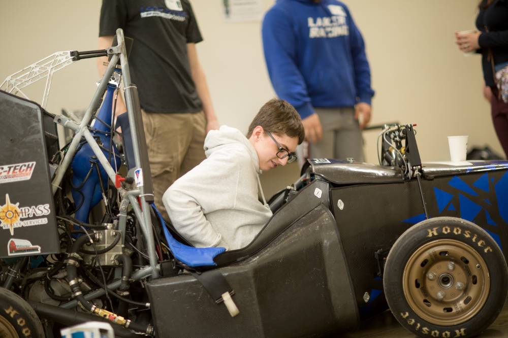 high school students sitting in a laker racer car